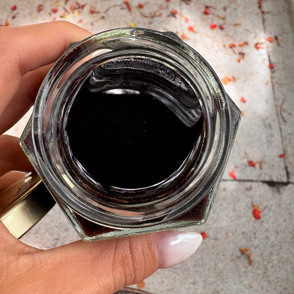 This picture shows the Herbal infused Syrup finished product. Dark in color from the Elderberries and thick consistency like honey.
